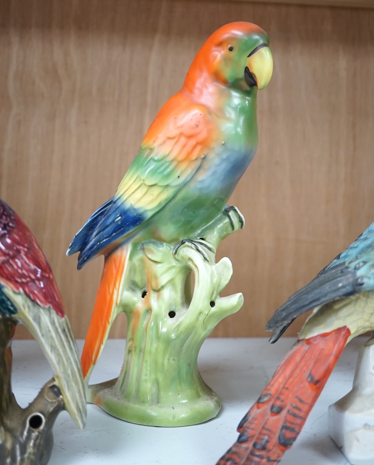 A group of twelve ceramic parrots including one by S Hancock & Sons, largest 24cm high. Condition - mostly good